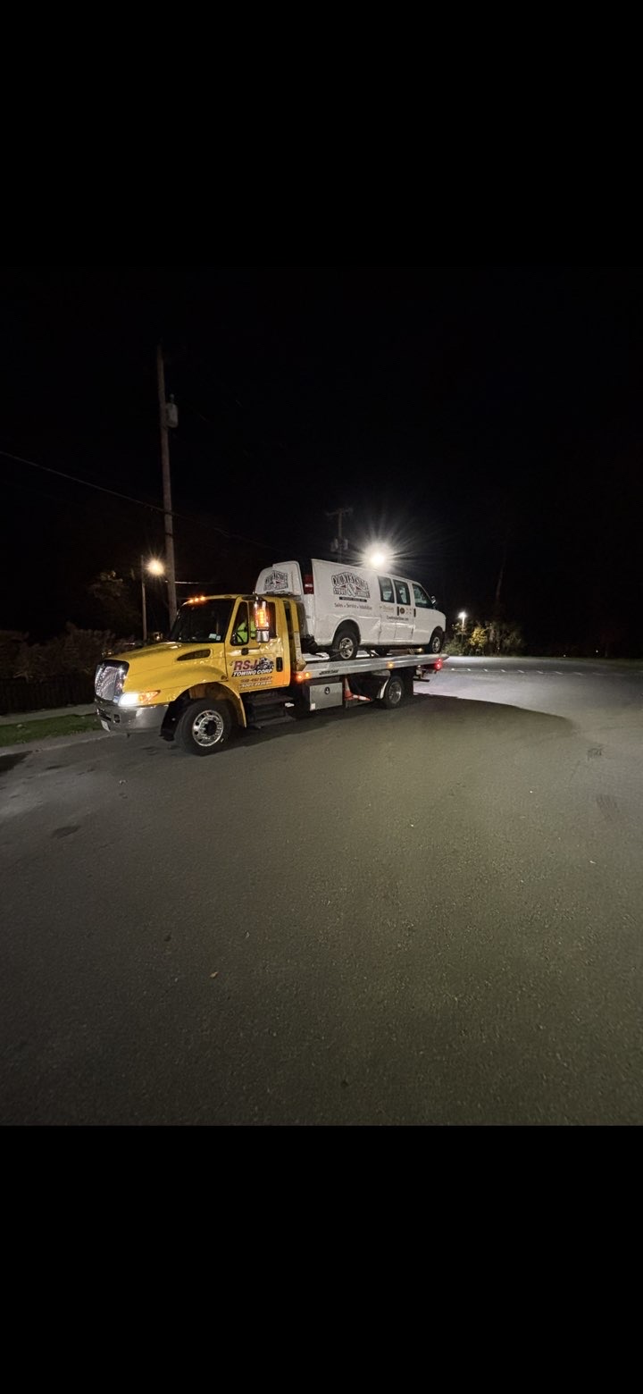 RSJ Towing flatbed truck at night with van loaded
