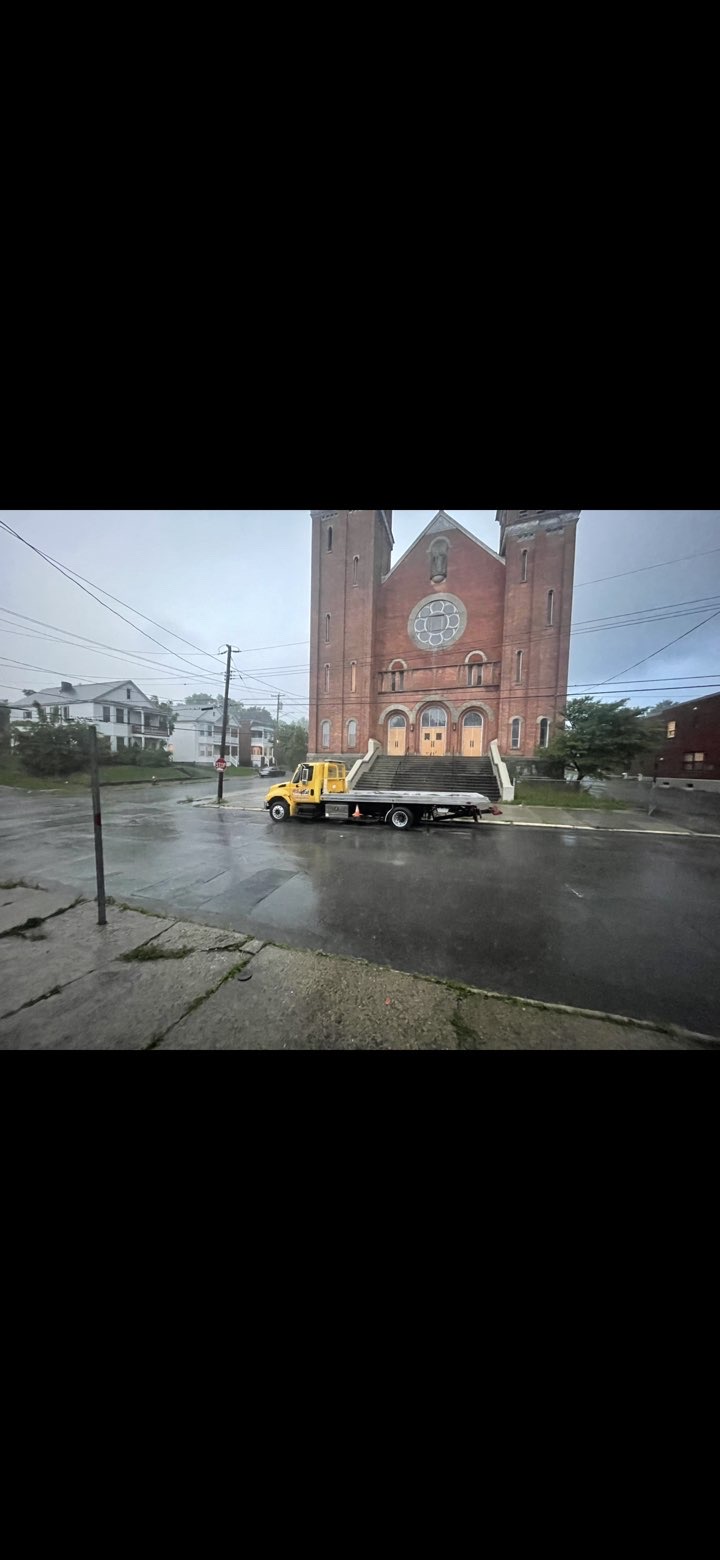 RSJ Towing truck in front of church in the rain