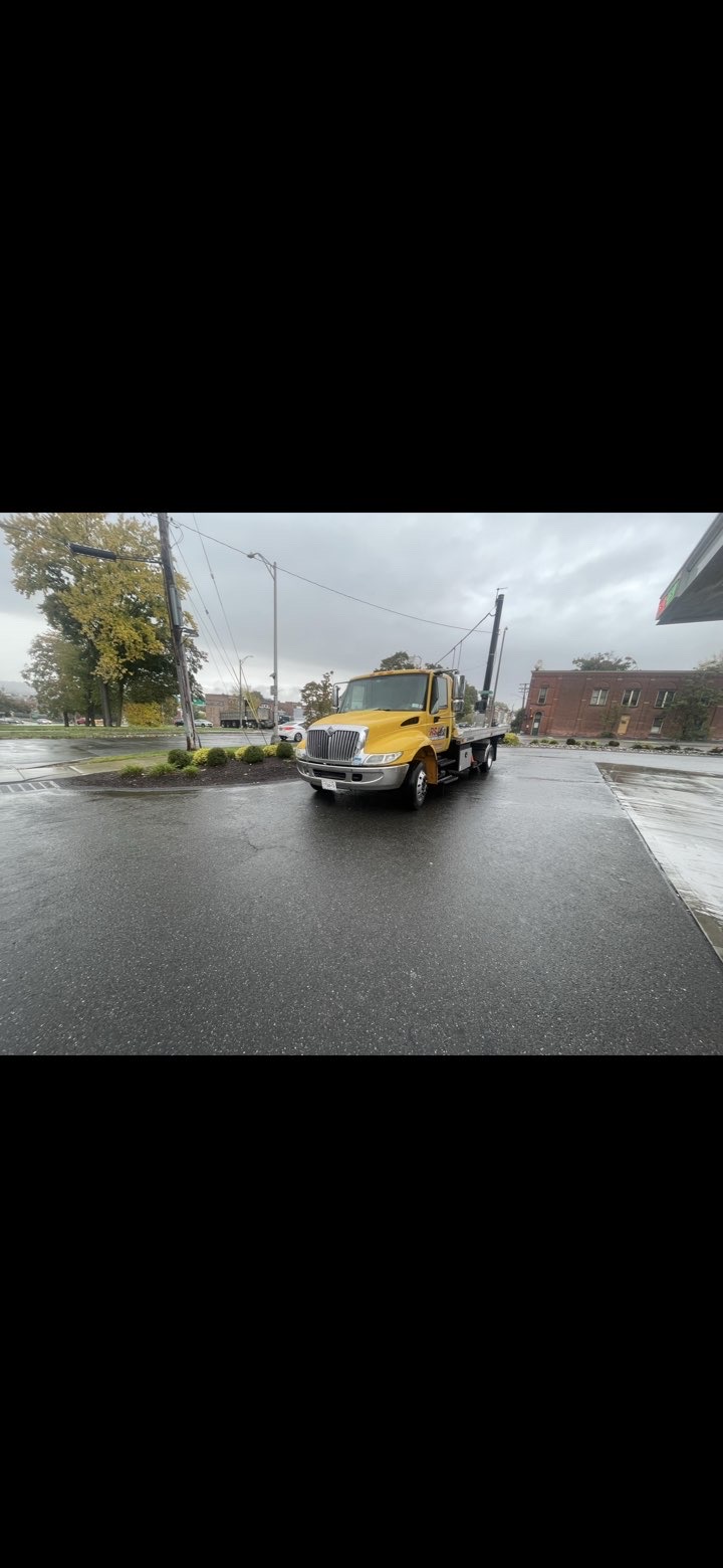 RSJ Towing truck in rainy parking lot